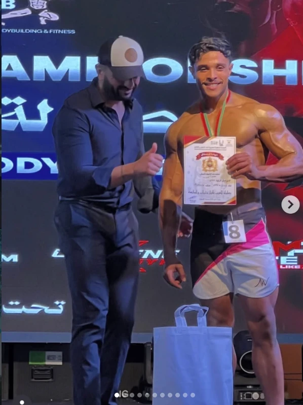 Mohamed Ahizoune receiving a medal and holding his competition certificate